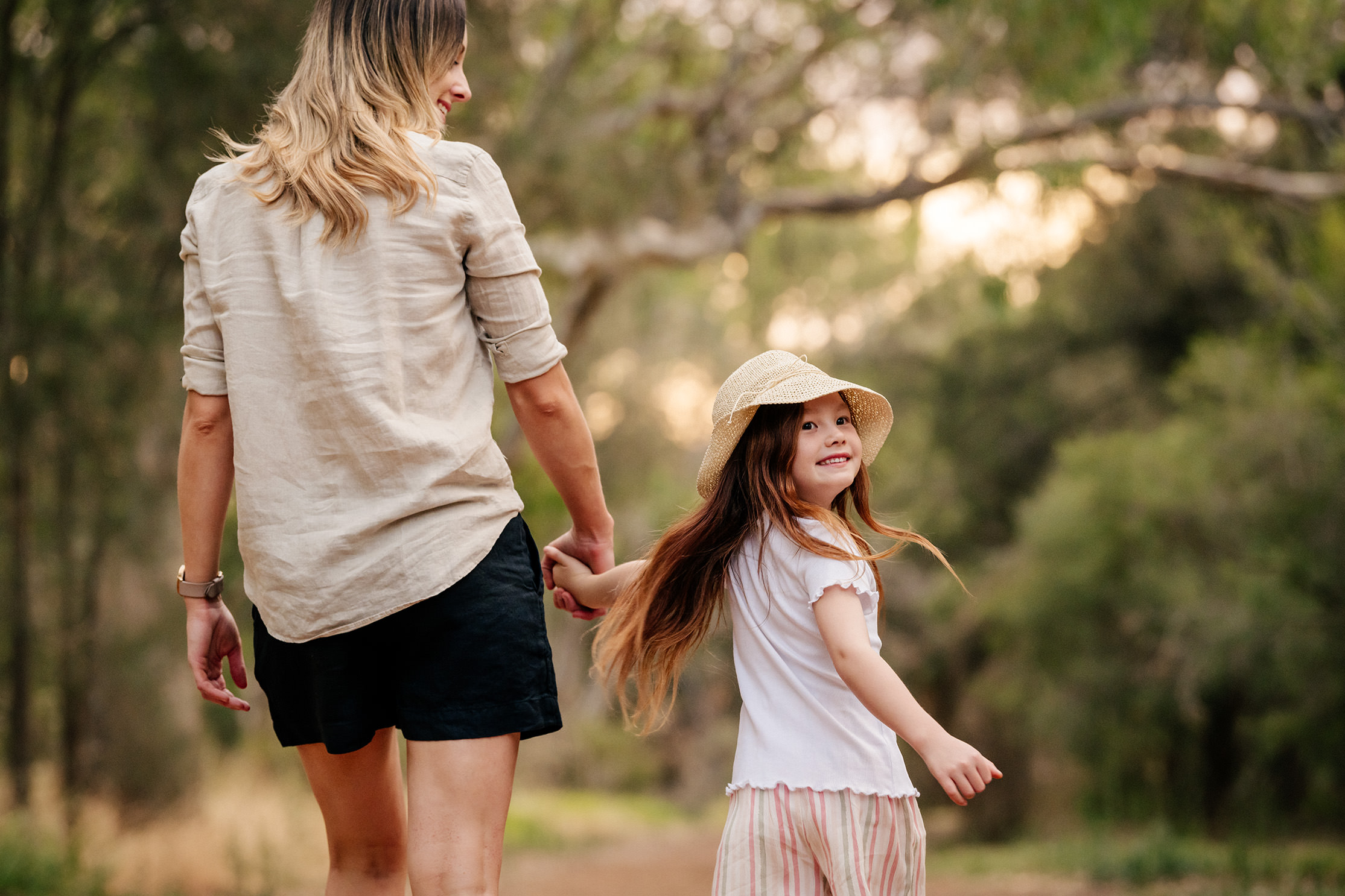 mother and daughter walking through a trail in a park in rivermark